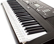 Close-up of a black electronic keyboard with black and white keys, various control buttons, and a digital display panel.